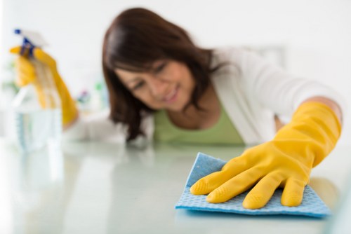 South Kensington cleaning professional tidying a bright living room
