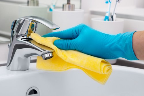 Cleaner wearing PPE including gloves and mask as part of safe cleaning practice